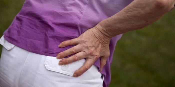 La mujer sostiene la mano en la cadera