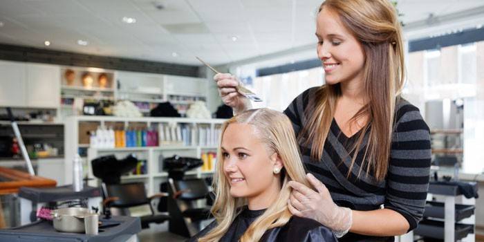 Cabeleireiro tinge o cabelo de um cliente