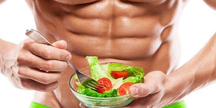 El hombre sostiene un plato con ensalada en sus manos