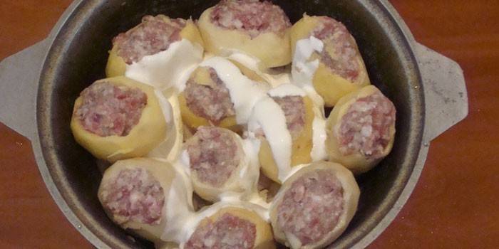 Batatas recheadas com carne picada e creme de leite em um caldeirão antes de cozinhar