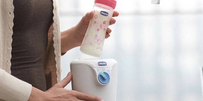 Chicco ohrievač a fľašu v ženských rukách