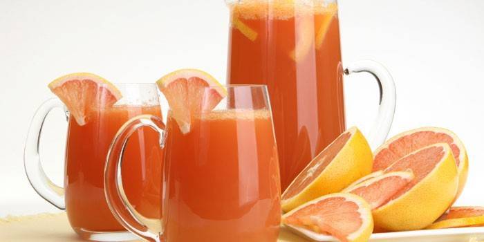Jugo de toronja en una jarra y tazas