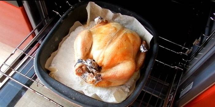 Pollo en una bandeja para hornear con sal