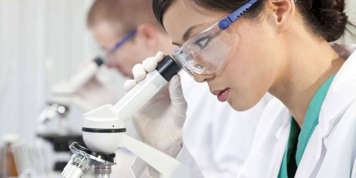 Niña mirando a través de un microscopio