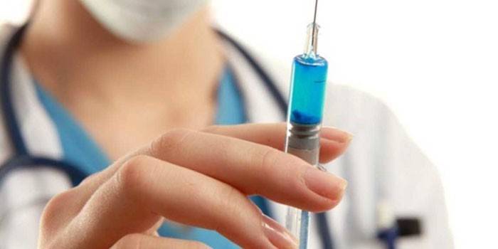 Una jeringa con un medicamento en la mano del médico.