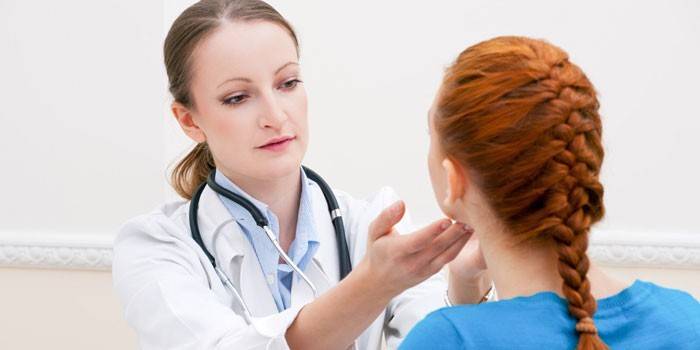 O médico palpa os gânglios linfáticos da menina