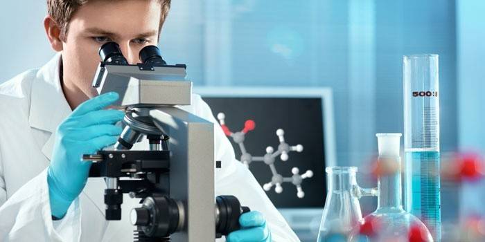Laboratórny technik pri pohľade cez mikroskop