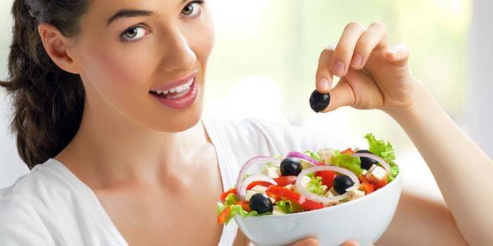 Niña sostiene un plato con ensalada en sus manos