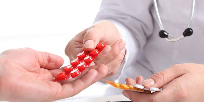 O médico passa as pílulas para o paciente