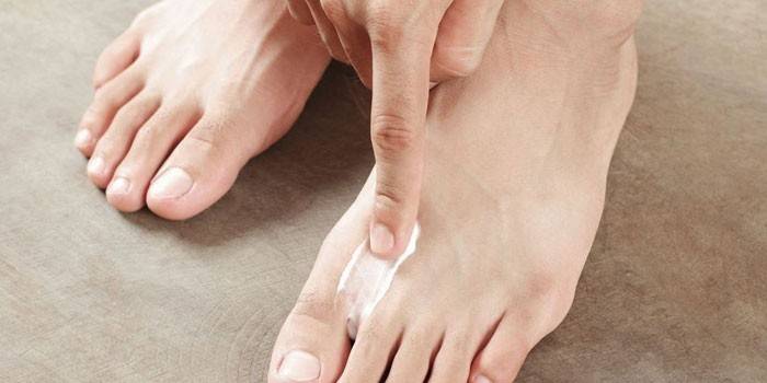 El hombre aplica crema en su pierna