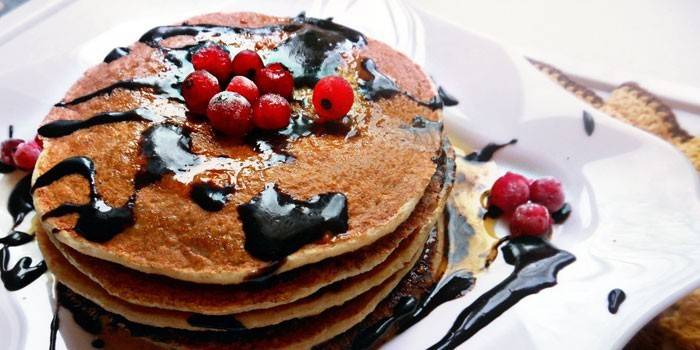 Tortitas preparadas con salsa de chocolate y bayas en un plato