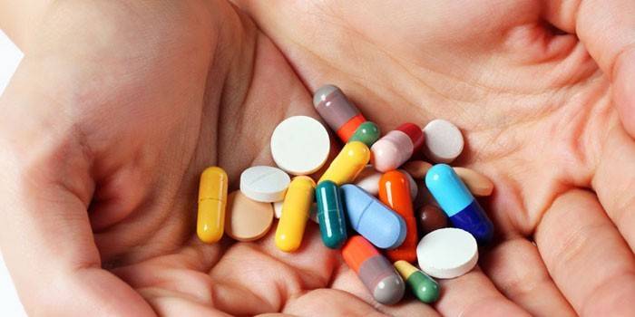 Pastillas y cápsulas en las palmas.