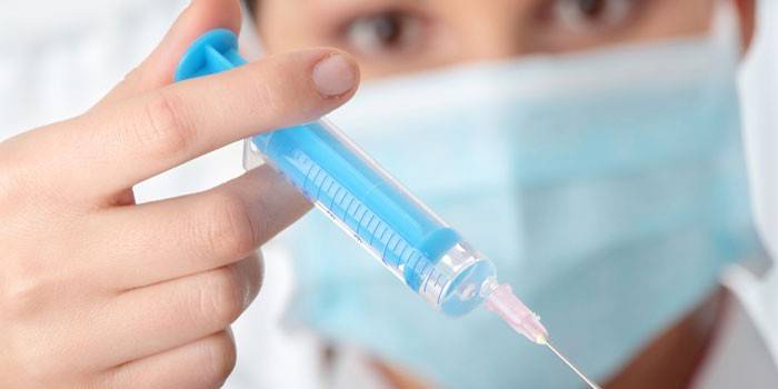Zdravotník s injekčnou striekačkou v ruke
