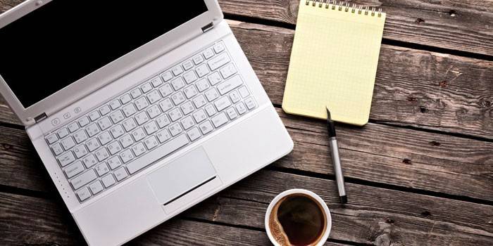 Laptop, notebook e xícara de café