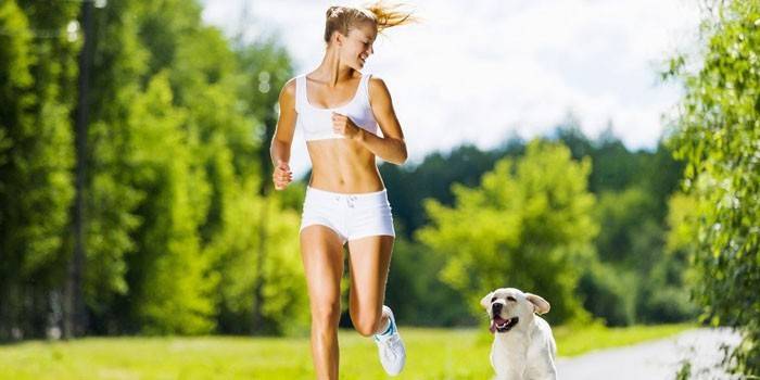 Niña corre con un perro en el parque