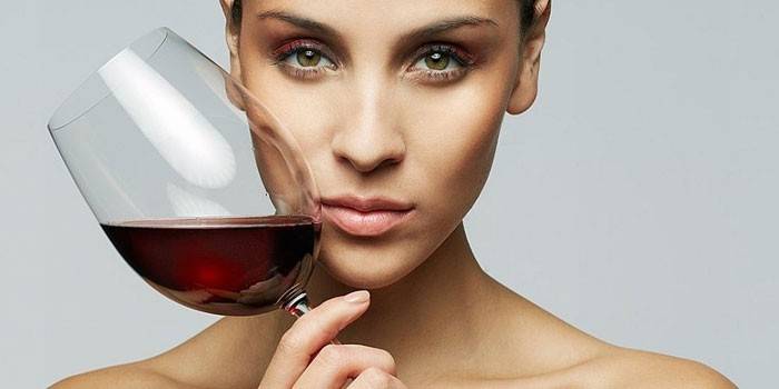 Chica con una copa de vino en la mano.