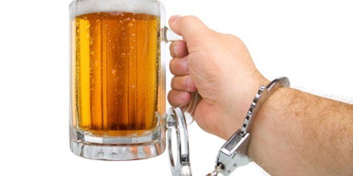 Hombre sujeto a un vaso de cerveza