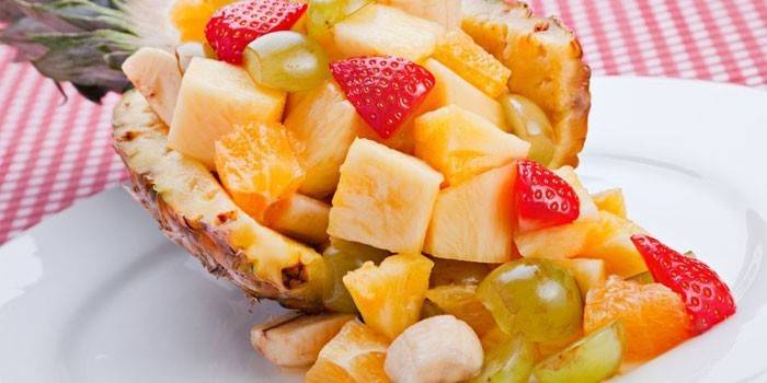 Salada de frutas em uma metade de abacaxi