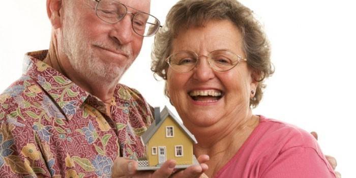 Mulher e homem com uma casa de brinquedo na mão