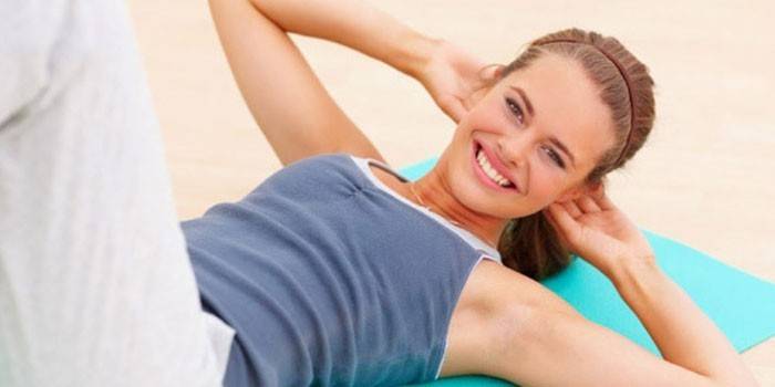 Chica haciendo ejercicio abdominal acostada de espaldas