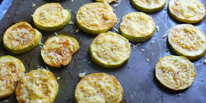 Círculos de calabacín en una bandeja para hornear con queso