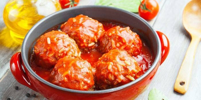 Albóndigas en arroz con salsa de tomate en una sartén