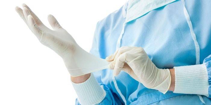 O médico coloca uma luva