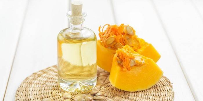 Botella de aceite de calabaza y rodajas de calabaza