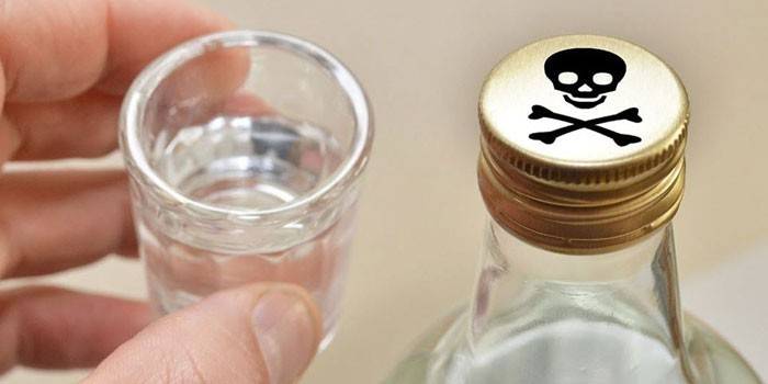 Garrafa de álcool com um sinal de veneno na tampa e um copo na mão
