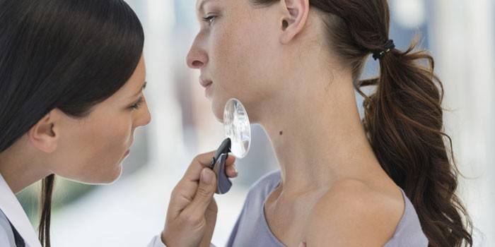 El dermatólogo examina la piel de una niña.