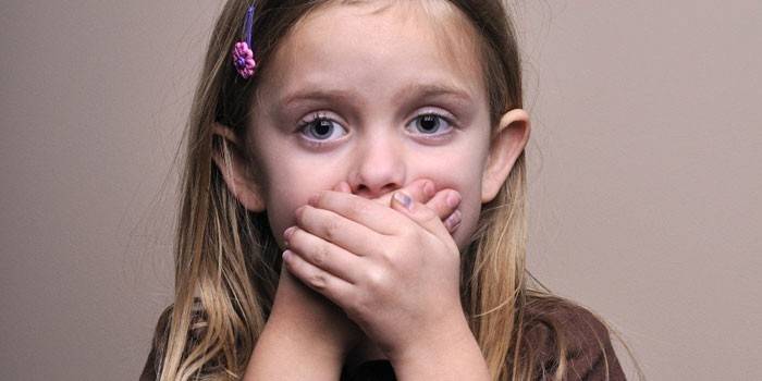 Garota fecha a boca com as mãos
