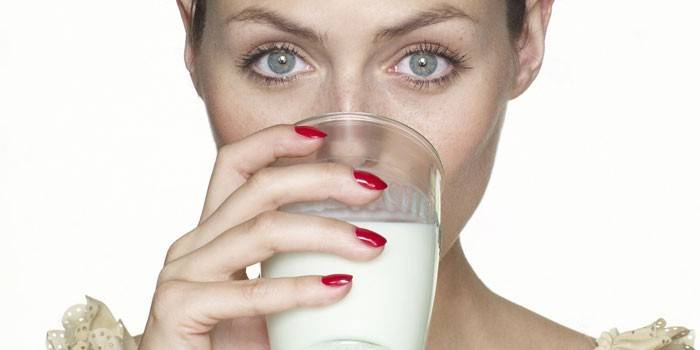 Niña bebe leche de un vaso