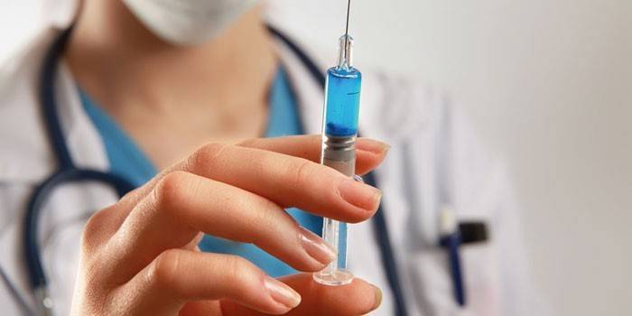 Una jeringa con un medicamento en la mano del médico.