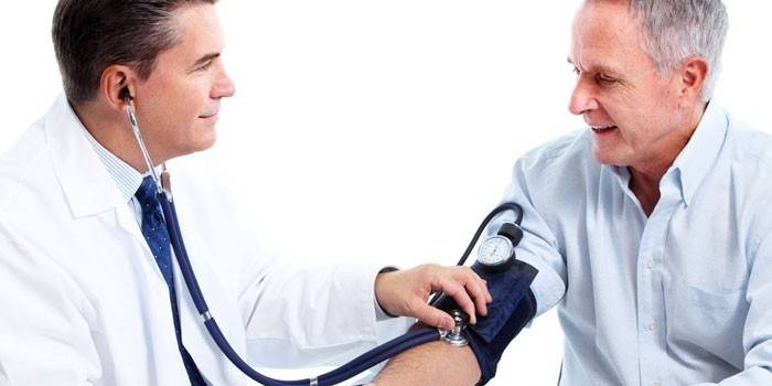 El doctor mide la presión de un hombre.