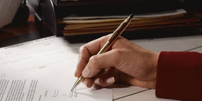 Mujer firma un documento
