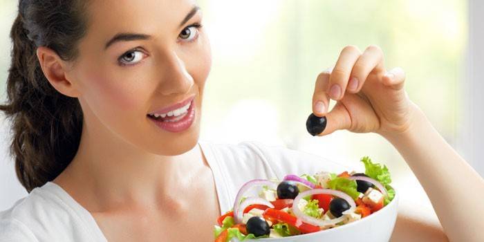 Chica con una ensalada en las manos.