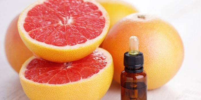 Grapefruitový olej v pohári a grapefruit