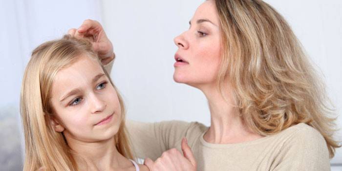 Mãe examina a cabeça das meninas