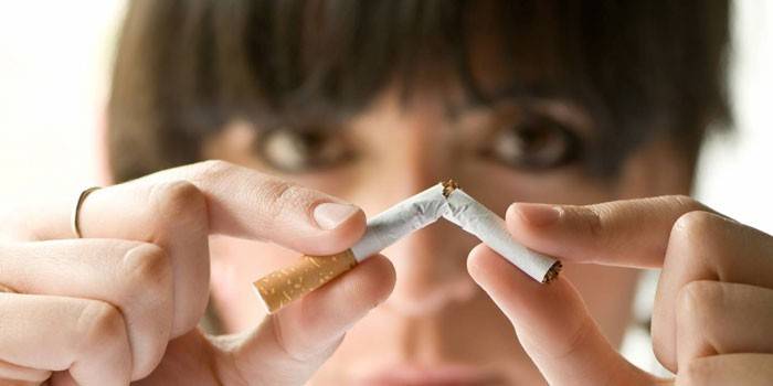 Mulher quebra um cigarro
