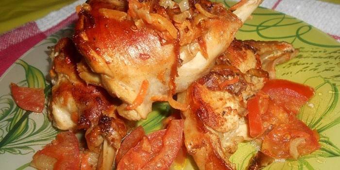 Fatias de coelho assadas no forno com cebola e tomate