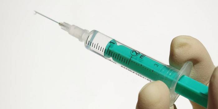 Seringa médica com uma substância na mão