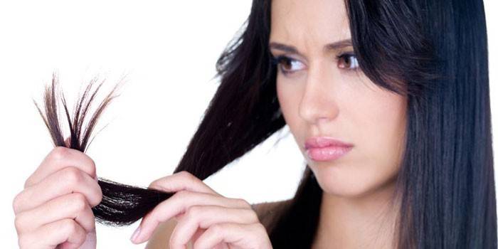 Menina olha para as pontas do cabelo