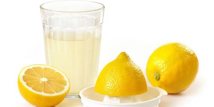 Suco de limão em um copo e limões