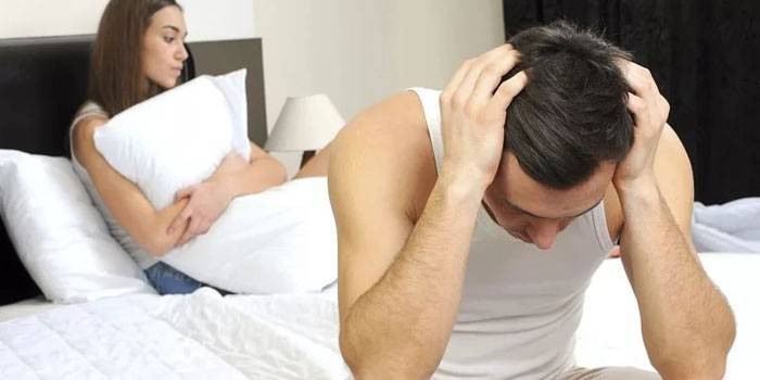 O cara está sentado na cama no quarto