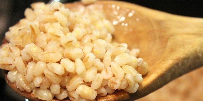 Owsianka jęczmienna w drewnianą łyżką