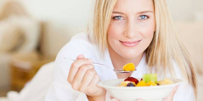 Niña comiendo ensalada de frutas