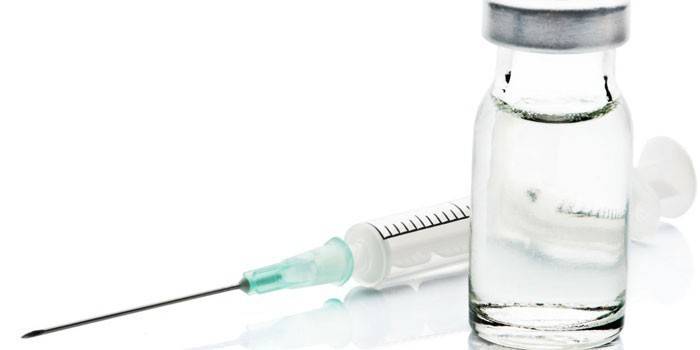 Seringa e droga em um frasco