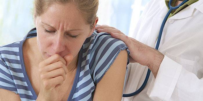 El médico escucha los pulmones del paciente con un fonendoscopio.