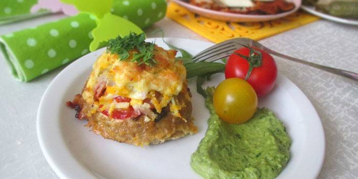 Pilha de carne picada com tomate e queijo em um prato com purê de batatas