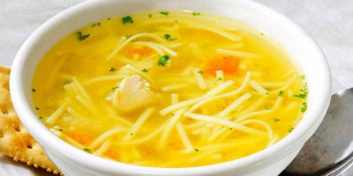 Caldo de galinha com macarrão caseiro em um prato